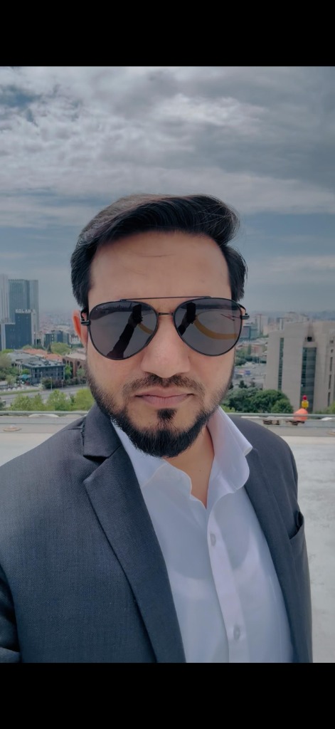 إعجاز أحمد في الهواء الطلق وخلفه أفق المدينة